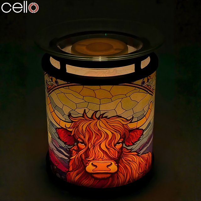 Cello Highland Cow Tealight Wax Warmer illuminated at night, showing stained-glass Highland cattle design – stylish Highland cow lamp or light-up gift.