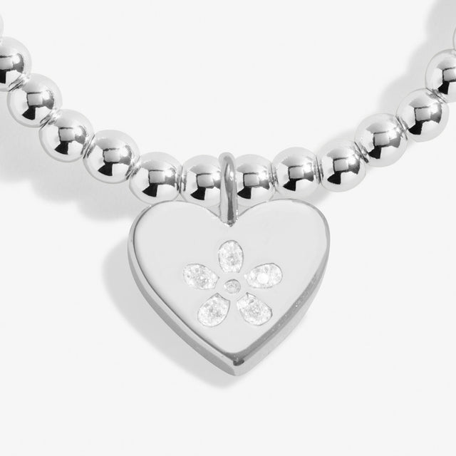 silver bracelet charm with flower form crystals inside heart charm