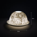 Cello porcelain tealight holder dome featuring different breeds of dogs all over the dome. Dimensions: 8cm height, 12cm width, displayed against a dark background.