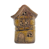 Front view of the yellow Silk Weaver’s Cottage light-up ceramic house with intricate Tudor-style windows and warm LED glow.