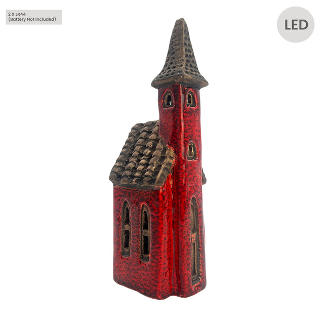 Side view of the Cello Tales from the Village Crimson Tower red ceramic LED house showing tall spire, arched windows, and hand-glazed finish.