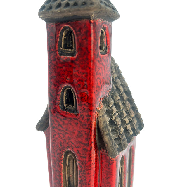 Close-up of the Crimson Tower ceramic pottery house highlighting textured roof tiles, arched window frames, and artisan red glaze.