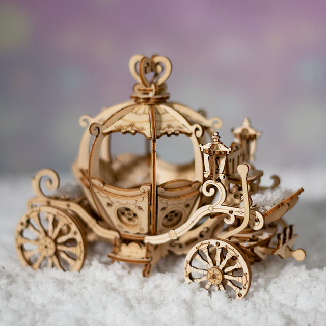 Wooden ROBOTIME Rolife kits Pumpkin Cart TG302 on a soft surface with a blurred background