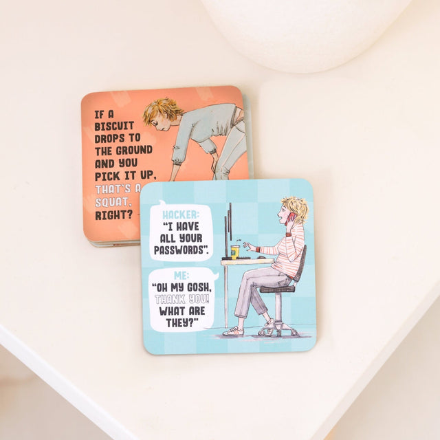 Two drinks coasters with humorous designs on a white surface