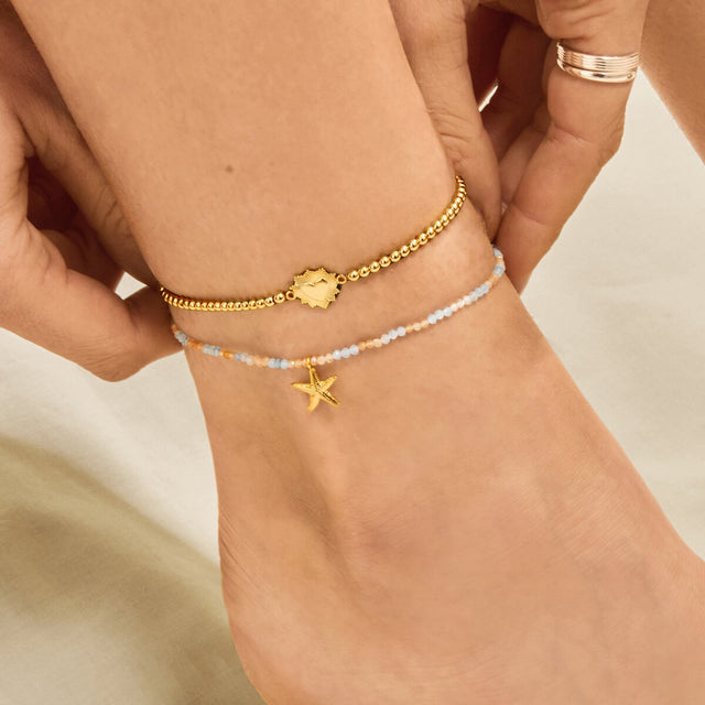 Beaded gold anklet with starfish charm styled on ankle