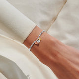Mixed metal heart charm bracelet worn on wrist