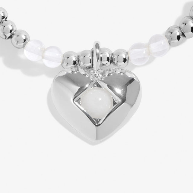 Close-up of rock crystal birthstone heart charm on Joma Jewellery bracelet