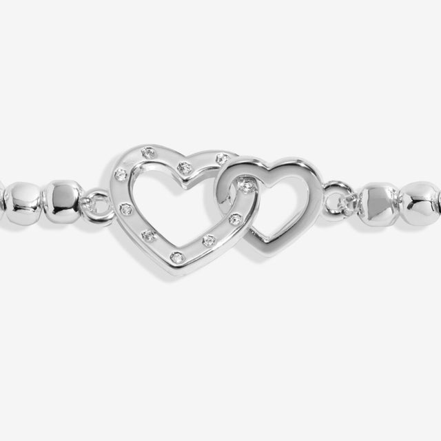 Close up of interlinked heart charms on gran bracelet