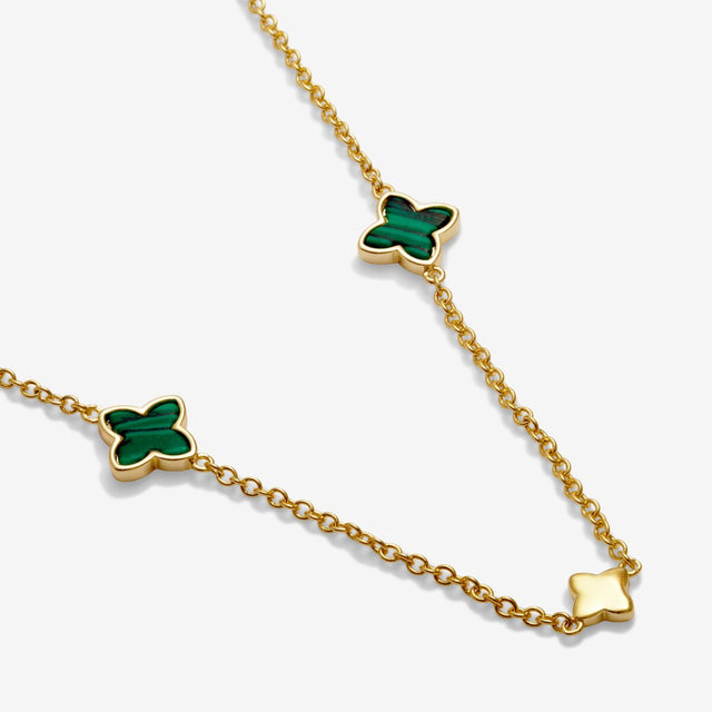 Fine chain and green charm detail on clover gold necklace