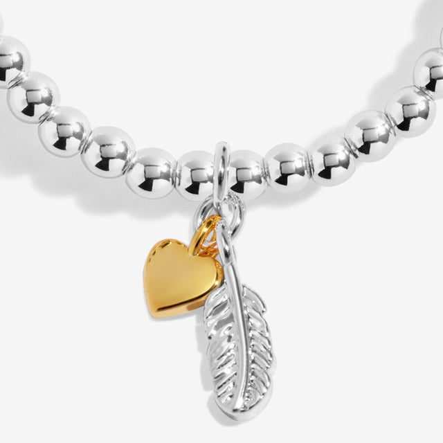 Close up of feather and heart charms on silver remembrance bracelet