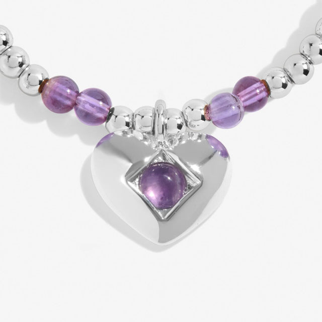 Close-up of amethyst birthstone heart charm on Joma Jewellery bracelet