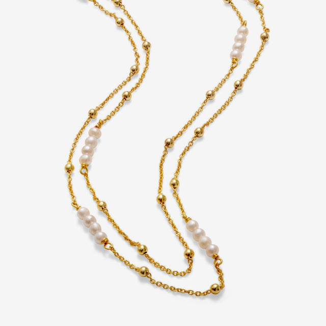 Detail of double layered gold pearl necklace chains