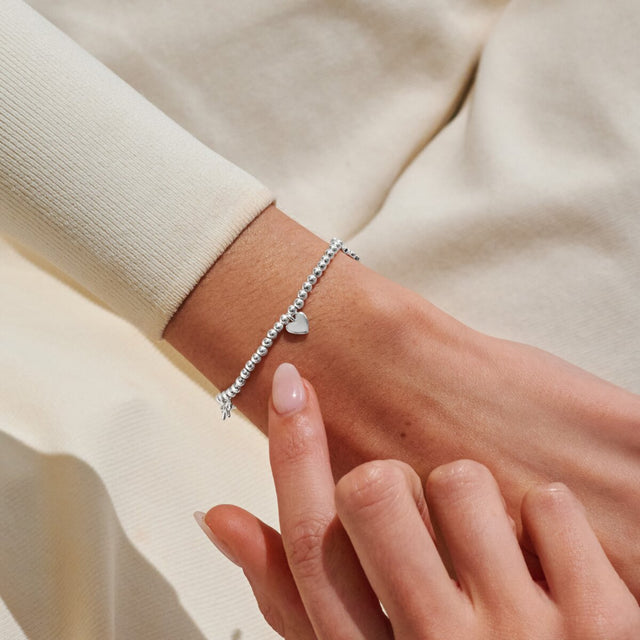 Silver Life’s A Charm Happy Birthday bracelet worn on wrist