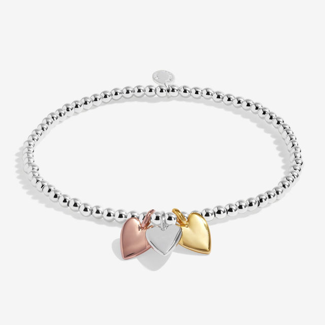 Silver beaded stretch bracelet with silver, gold and rose gold heart charms