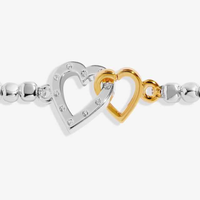 Close up of silver and gold interlinked heart charms on Mother and Son bracelet