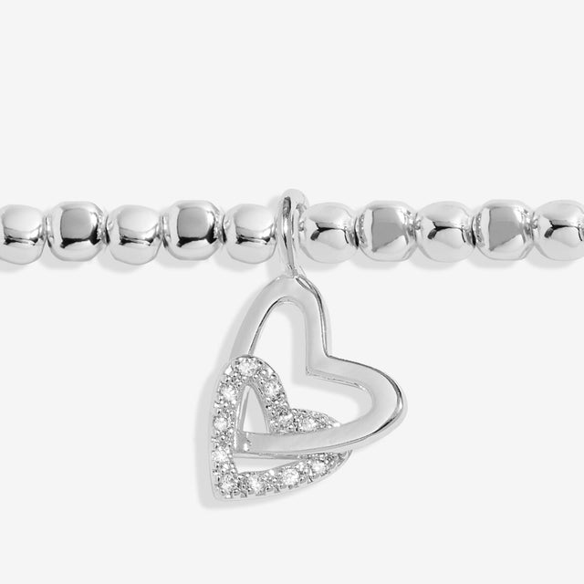 Close up of interlinked heart charms on silver daughter bracelet
