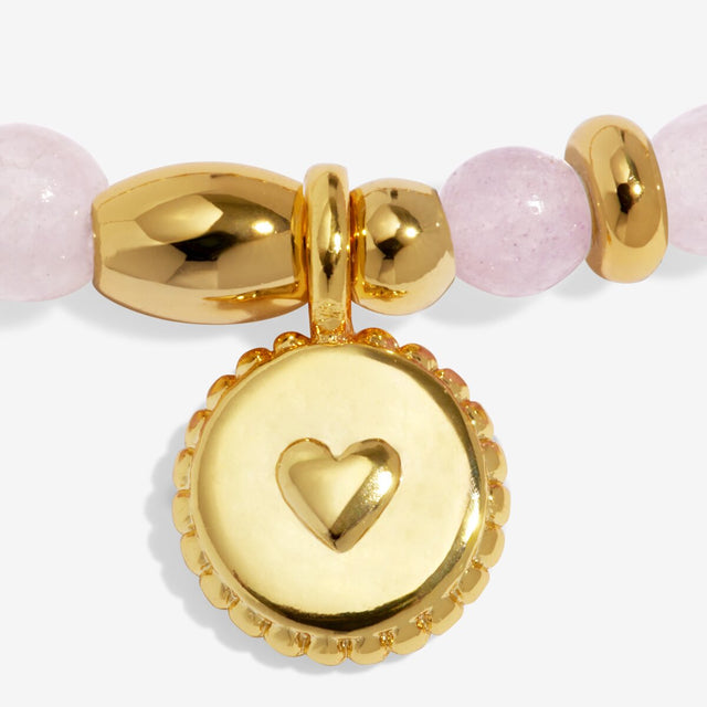 Close-up of gold heart charm on Joma Jewellery Love affirmation bracelet