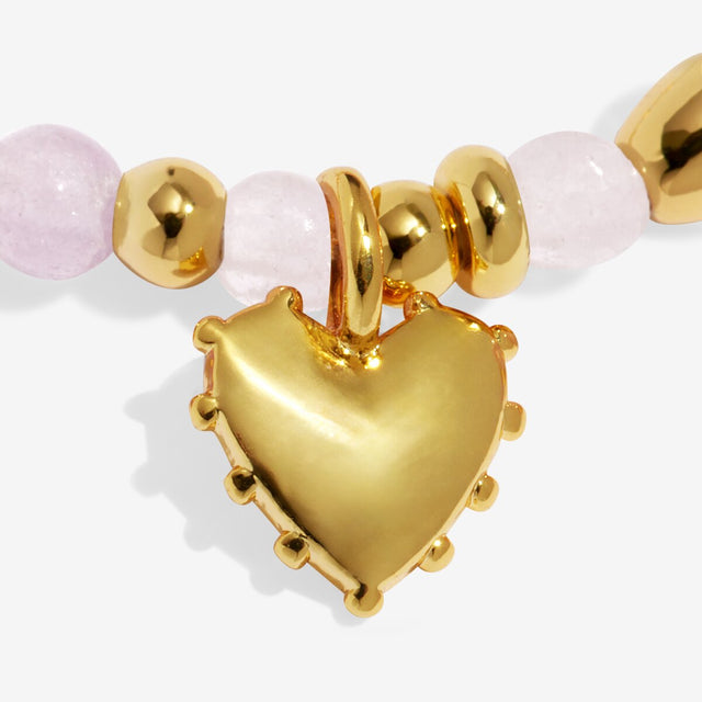 Close-up of gold heart charm on Joma Jewellery Love affirmation bracelet