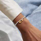 Silver beaded Joma bracelet with gold moon and heart charms worn on wrist