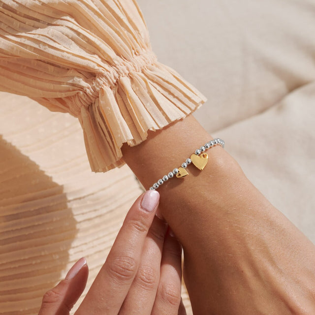 Silver and gold heart charm bracelet worn on wrist gift for granddaughter