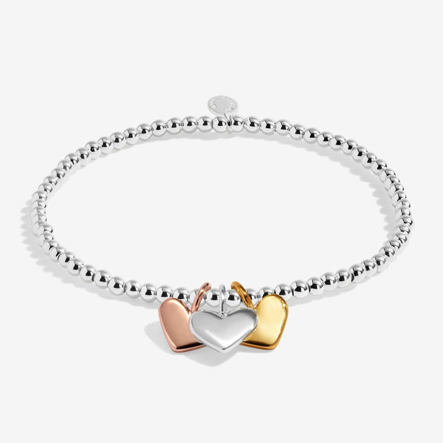 Silver beaded stretch bracelet with silver, gold and rose gold heart charms