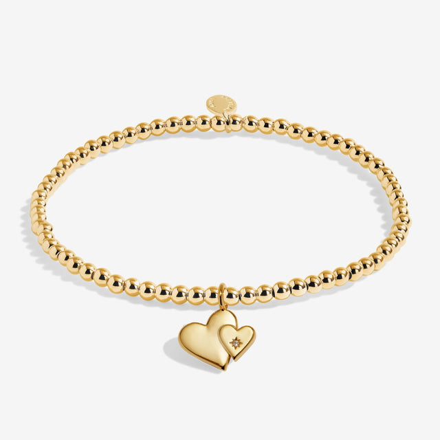 Gold plated beaded bracelet with two linked heart charms