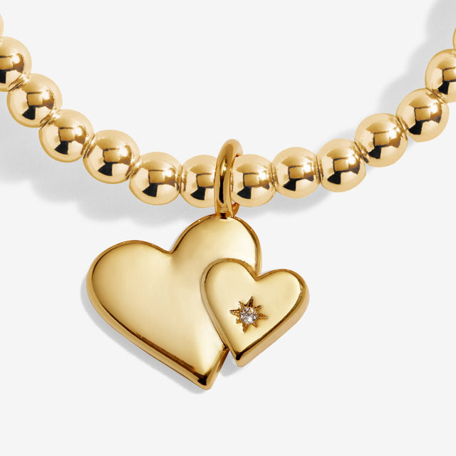 Close up of two linked heart charms on gold Mother’s Day bracelet