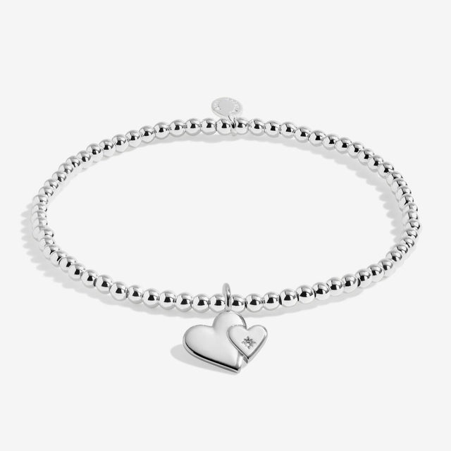 Silver plated beaded bracelet with two linked heart charms