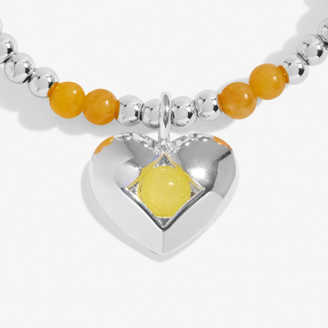 Close-up of yellow quartz birthstone heart charm on Joma Jewellery bracelet