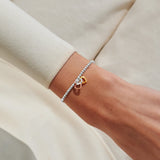Mixed metal heart charm bracelet worn on wrist