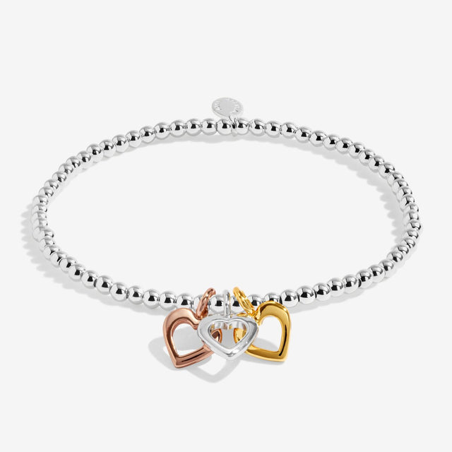 Silver beaded stretch bracelet with silver, gold and rose gold heart charms