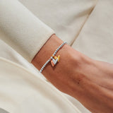 Mixed metal heart charm bracelet worn on wrist