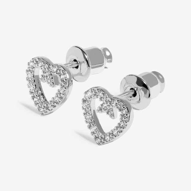 Heart-shaped silver stud earrings detail