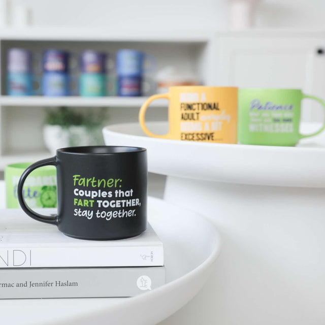 Splosh Fartner funny mug on a bright kitchen counter, humorous couple’s coffee mug with green text, perfect novelty gift idea for him or her.