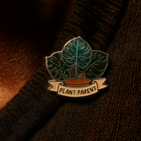 Close-up of Splosh Plant Lover enamel pin with green leaf design