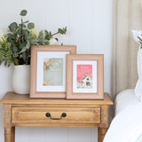 Wooden frame for photos displayed on wooden side table with home & family text detail