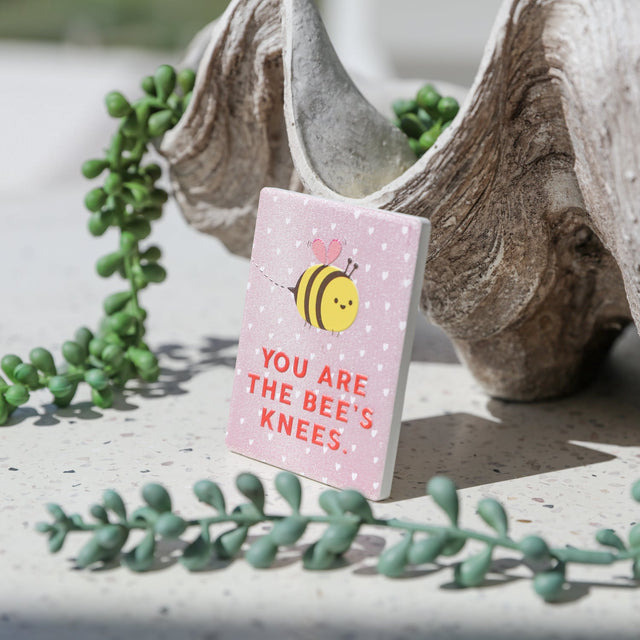 Bee-themed ceramic love magnet displayed on a surface